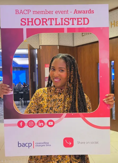 Mo smiling holding a BACP member event awards shortlisted frame